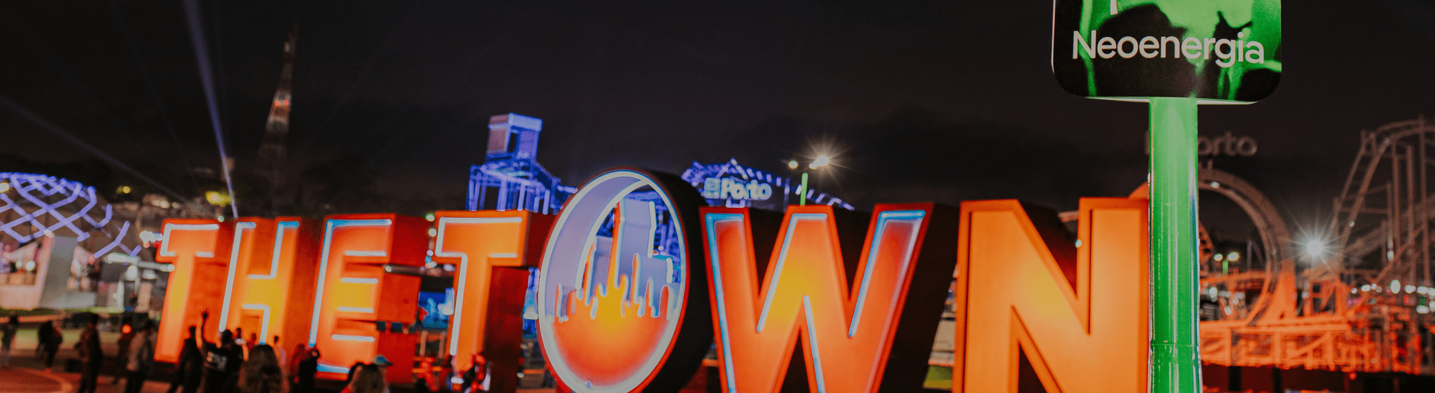 Letreiro do festival The Town e placa da Neoenergia a frente, em poste