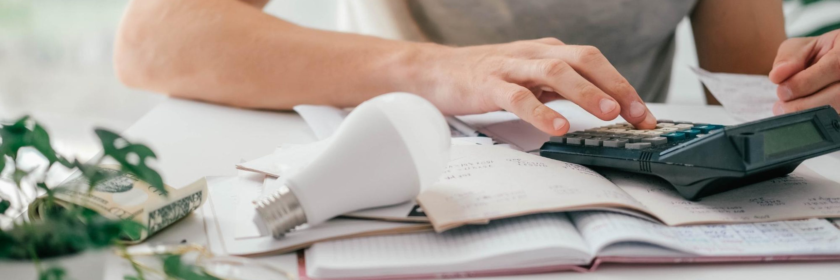 Pessoa calcula despesas de energia e analisa a conta de luz para controlar os gastos da casa. Conceito de economia de energia, planejamento financeiro e consumo consciente.